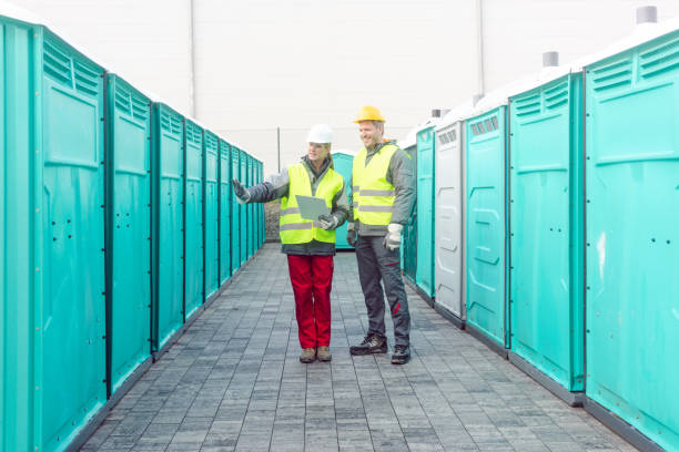 workers checking the portable toilets for rental purposes workers checking the portable toilets for rental purposes